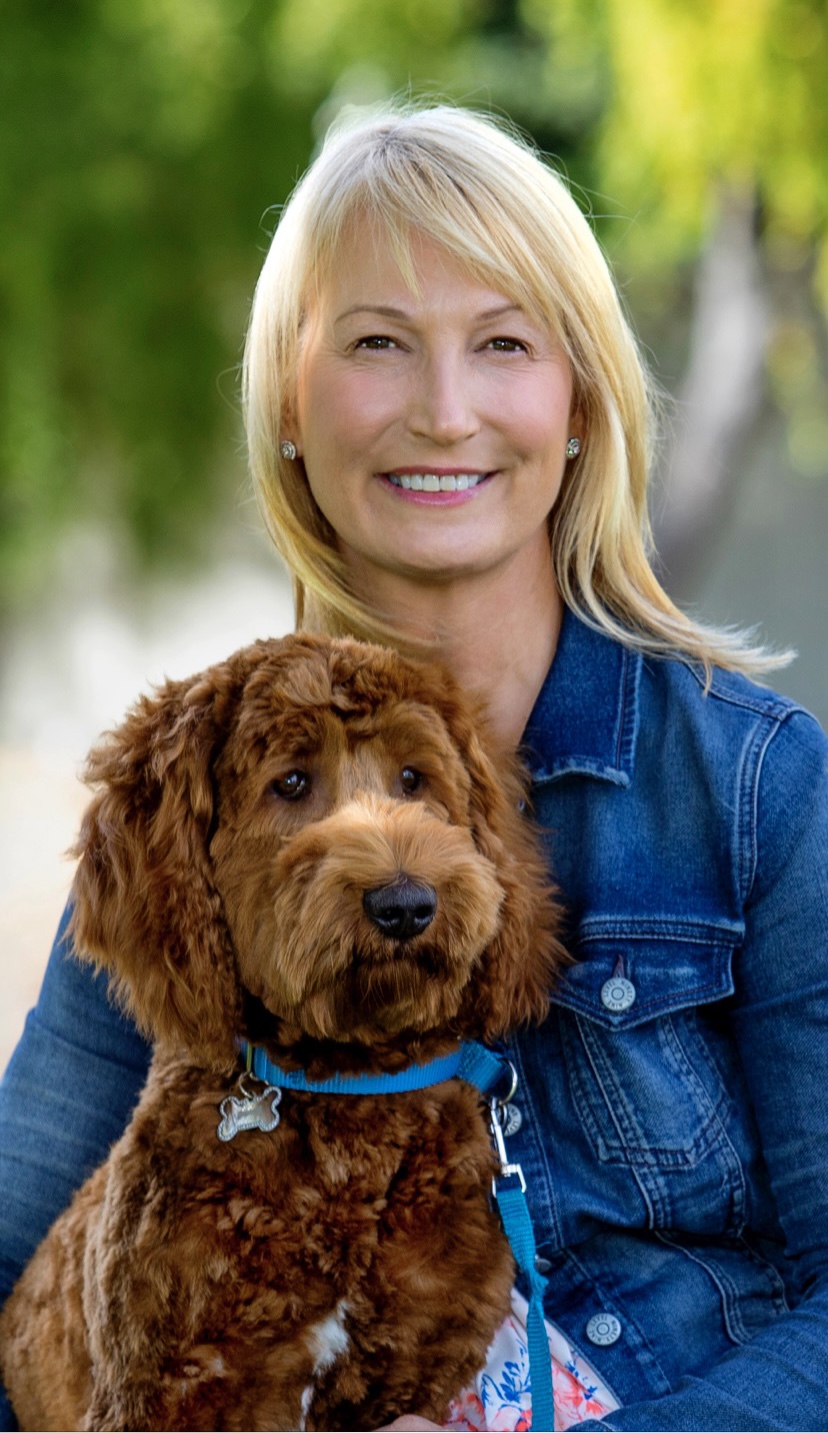 Heidi Diebel smiling with Ringo, her brown Australian Labradoodle